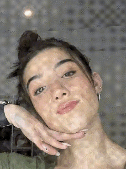 a close up of a woman 's face with her hands on her chin