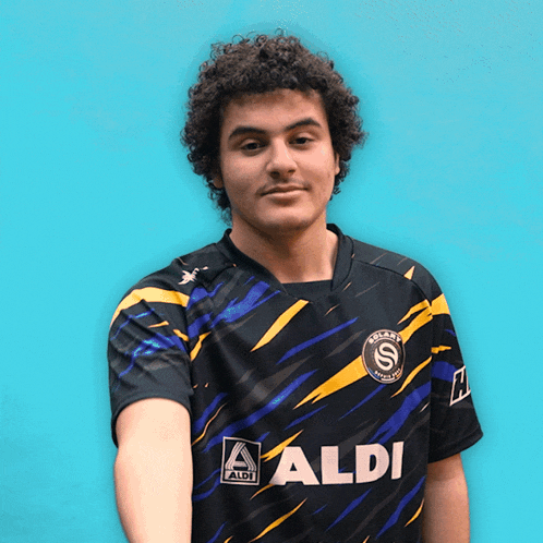 a man wearing a black and yellow shirt with aldi on the front