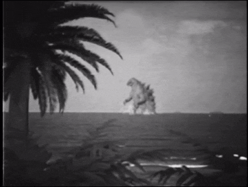 a black and white photo of a monster standing on a beach