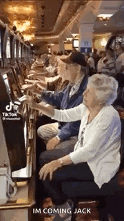 a group of elderly people are playing a slot machine in a casino .