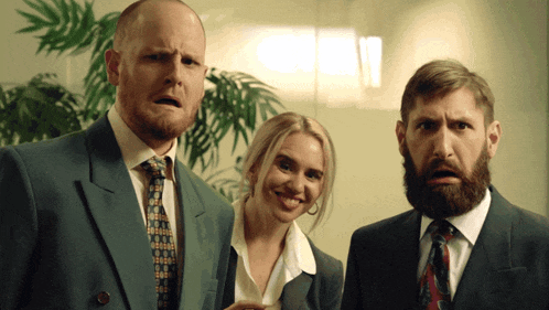 a man with a beard is standing next to a woman in a suit and tie