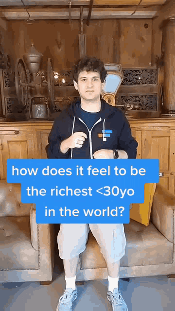 a man is sitting on a couch with a blue sign that says how does it feel