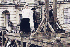 a man in a white hat is standing on a wooden platform