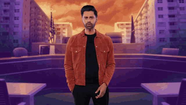 a man in a red jacket stands in front of a city skyline