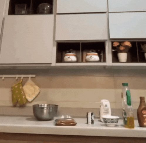 a kitchen counter with a bowl a mixer and bottles on it