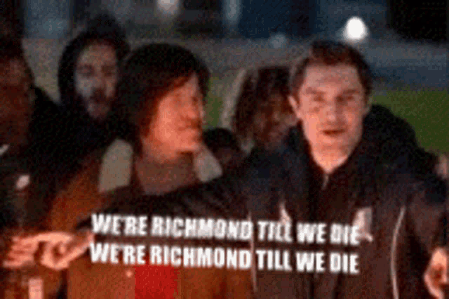 a group of people standing in front of a sign that says we 're richmond till we die we 're richmond till we die