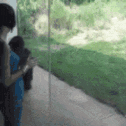 a blurred image of a person standing in front of a glass wall