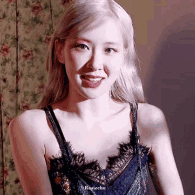 a woman with blonde hair is wearing a black lace top .