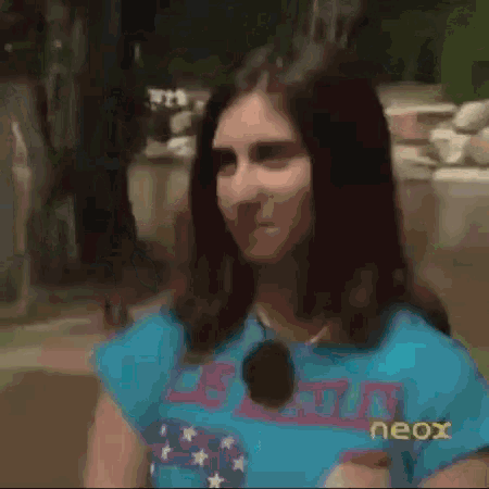 a woman with long hair is wearing a blue shirt that says neox