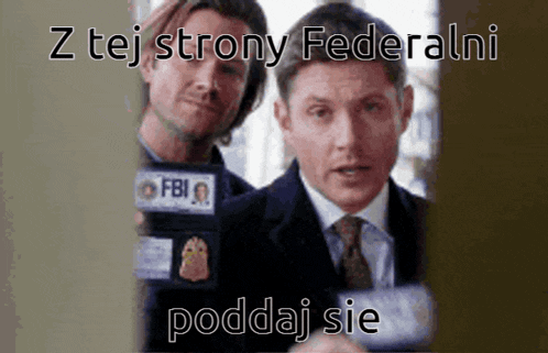 two men are standing next to each other and one has a fbi badge on his jacket