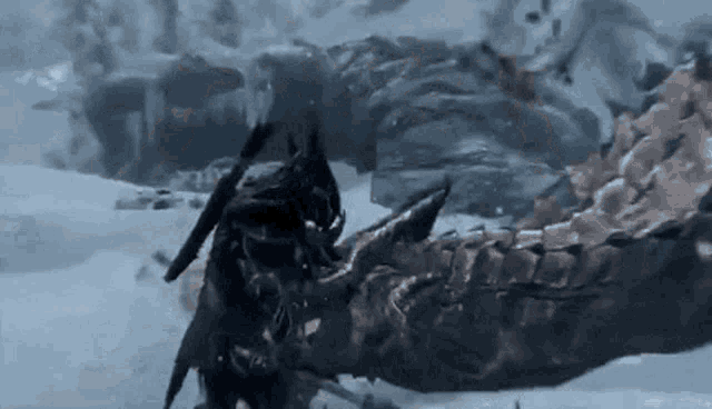 a person is standing next to a large dragon in the snow .