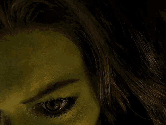 a close up of a woman 's face with green eyes
