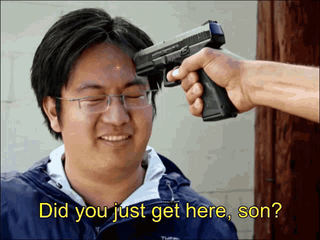 a man with glasses is getting a gun pointed at his head with the words did you just get here son below it