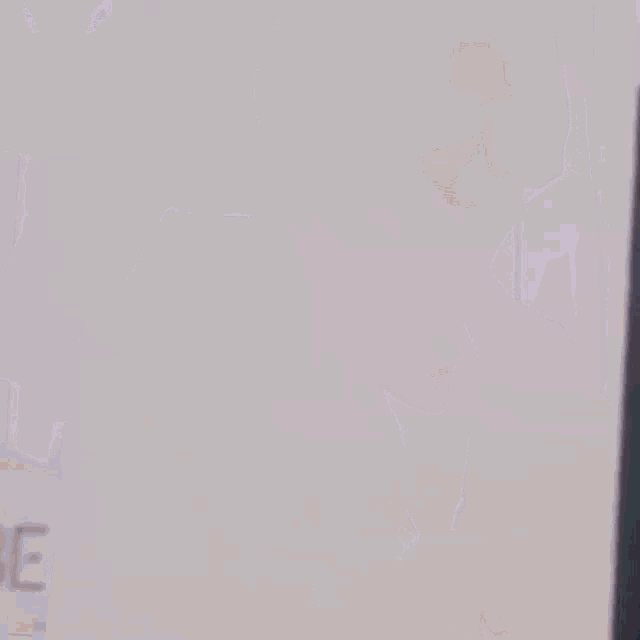 a man is peeking out from behind a laptop computer .
