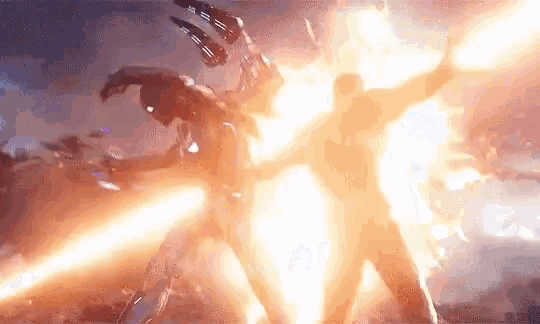 a man is standing in front of a fireball while another man is standing in the background .