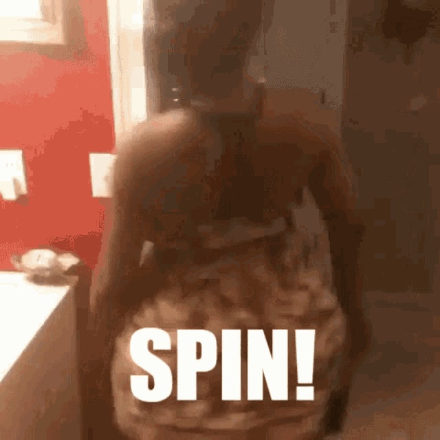 a woman is dancing in a bathroom with the word spin written on the floor