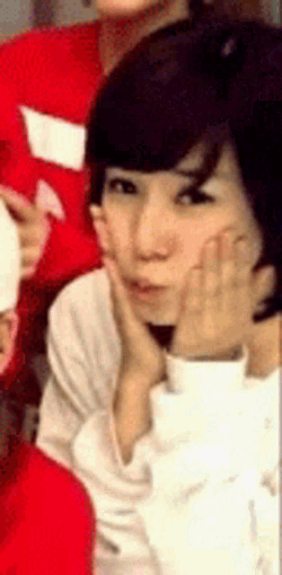 a close up of a woman 's face with her hand on her face
