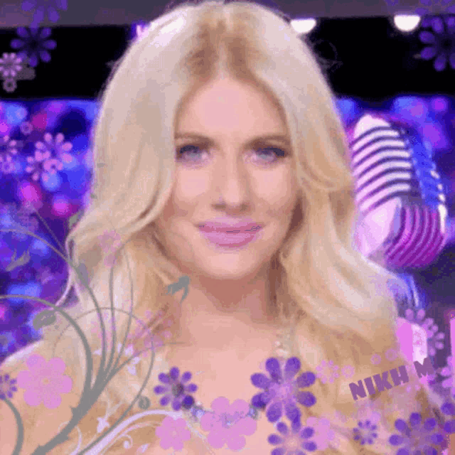 a close up of a woman 's face surrounded by purple flowers and a microphone