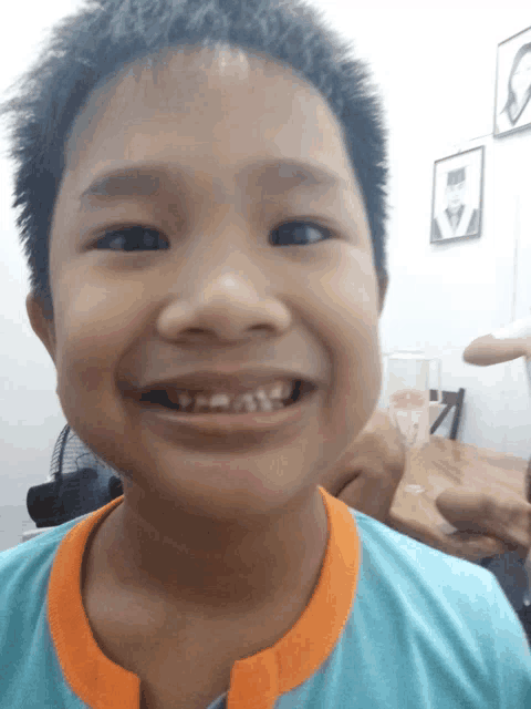 a young boy with a missing tooth smiles for a picture