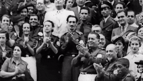 a black and white photo of a crowd of people clapping their hands