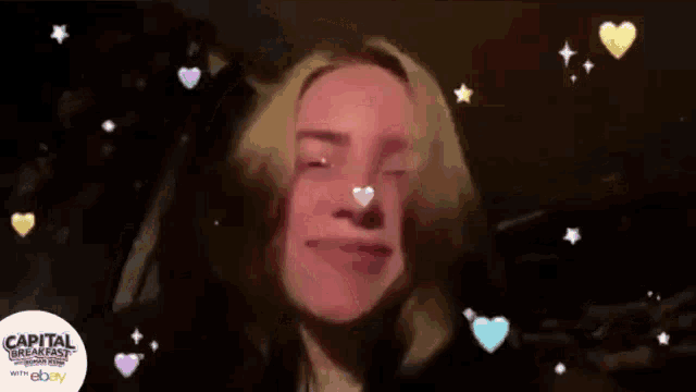 a woman with hearts on her face is surrounded by capital breakfast