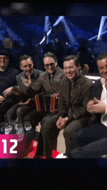 three men in suits and ties are sitting next to each other