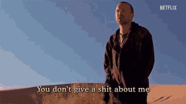 a man standing in the desert with the words " you don 't give a shit about me " behind him