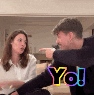 a man and a woman are sitting on a couch and the man is pointing at the woman and the word yo is behind them