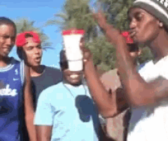 a group of young men are standing together and one of them is wearing a brooklyn jersey