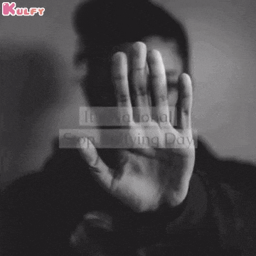 a black and white photo of a man covering his face with his hand .