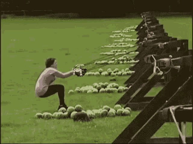 a woman is sitting on the ground pulling a watermelon with a rope .