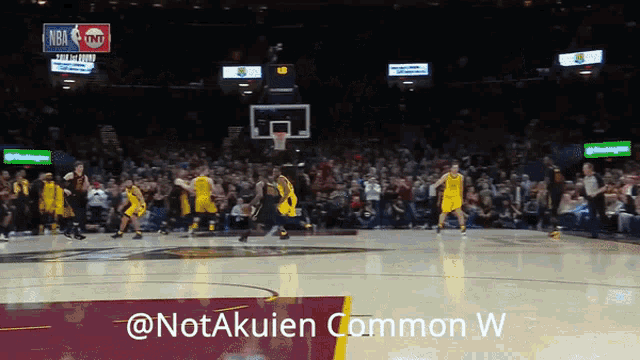 a basketball game is being played in front of a crowd with a tnt sign in the background