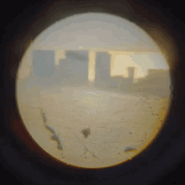 a view of a city through a telescope with buildings in the background