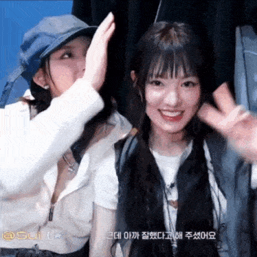 two girls are posing for a picture and one of them is wearing a hat that says ' sui ' on it