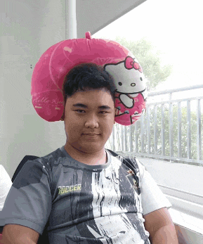 a man wearing a hello kitty pillow on his head