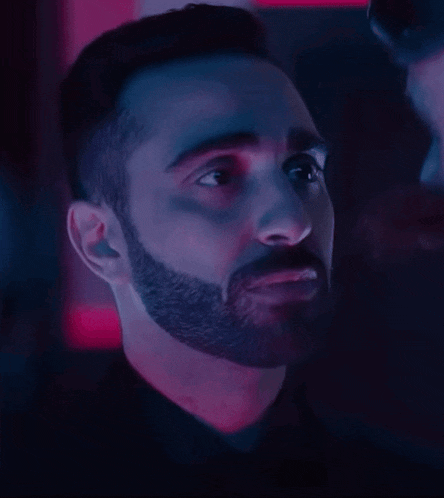 a man with a beard in a dark room