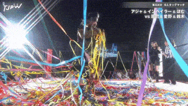 a wrestler is surrounded by confetti and ribbons with jpw written on the bottom left