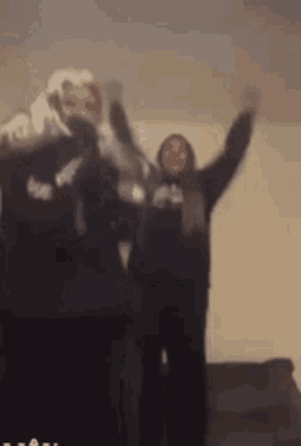 a blurry picture of two women standing next to each other .