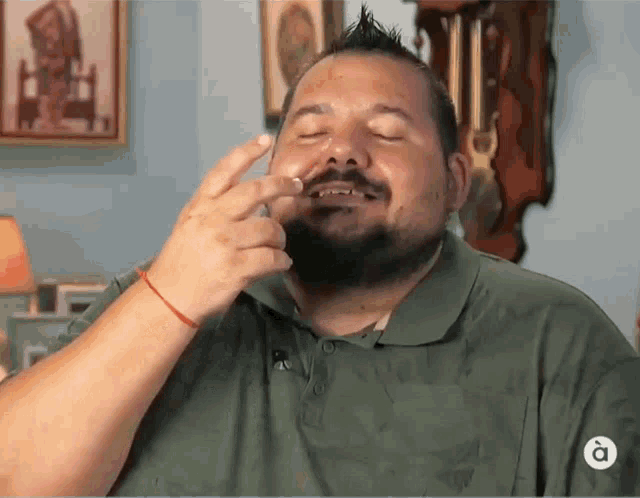 a man in a green shirt has a letter a on his shirt