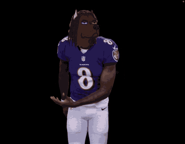 a man wearing a ravens jersey with the number 8