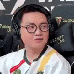 a man wearing headphones and glasses is sitting in a gaming chair .