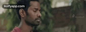 a man with a beard and ear piercings is looking at the camera .