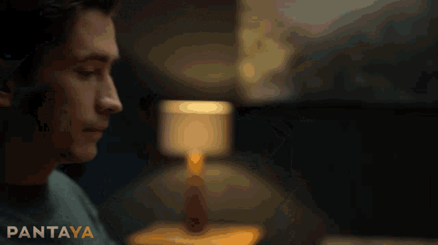a man is sitting in front of a lamp with pantaya written on the bottom