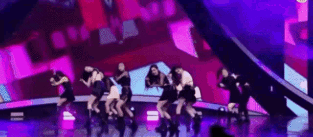 a group of young women are dancing on a stage .