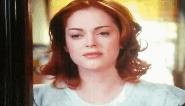a woman with red hair is looking at the camera .