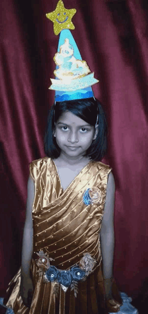 a little girl wearing a party hat with a star on top