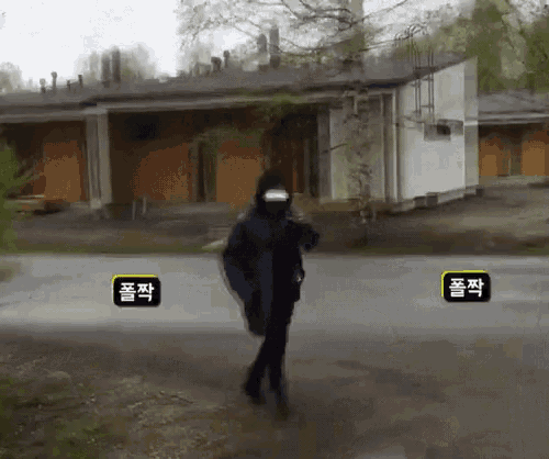 a person wearing a mask is walking down a street in front of a building with chinese characters on it