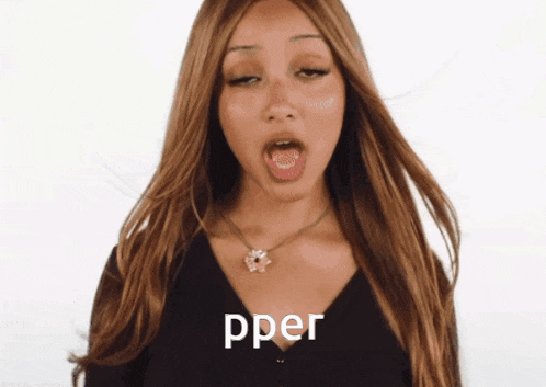 a woman wearing a black top and a necklace says pper