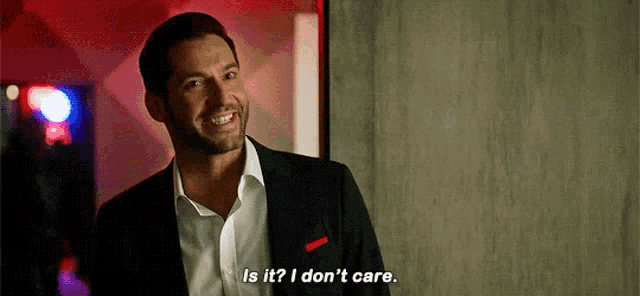 a man in a suit and white shirt is smiling and saying `` is it ? i don 't care '' .