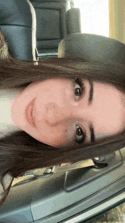 a close up of a woman 's face while sitting in a car